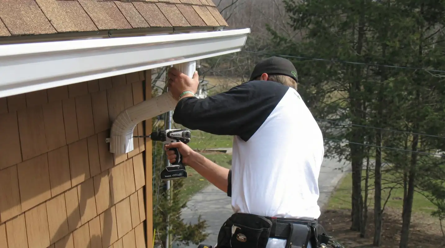 Professional contractor installing tan vinyl siding panels on a residential home exterior in Columbia, SC